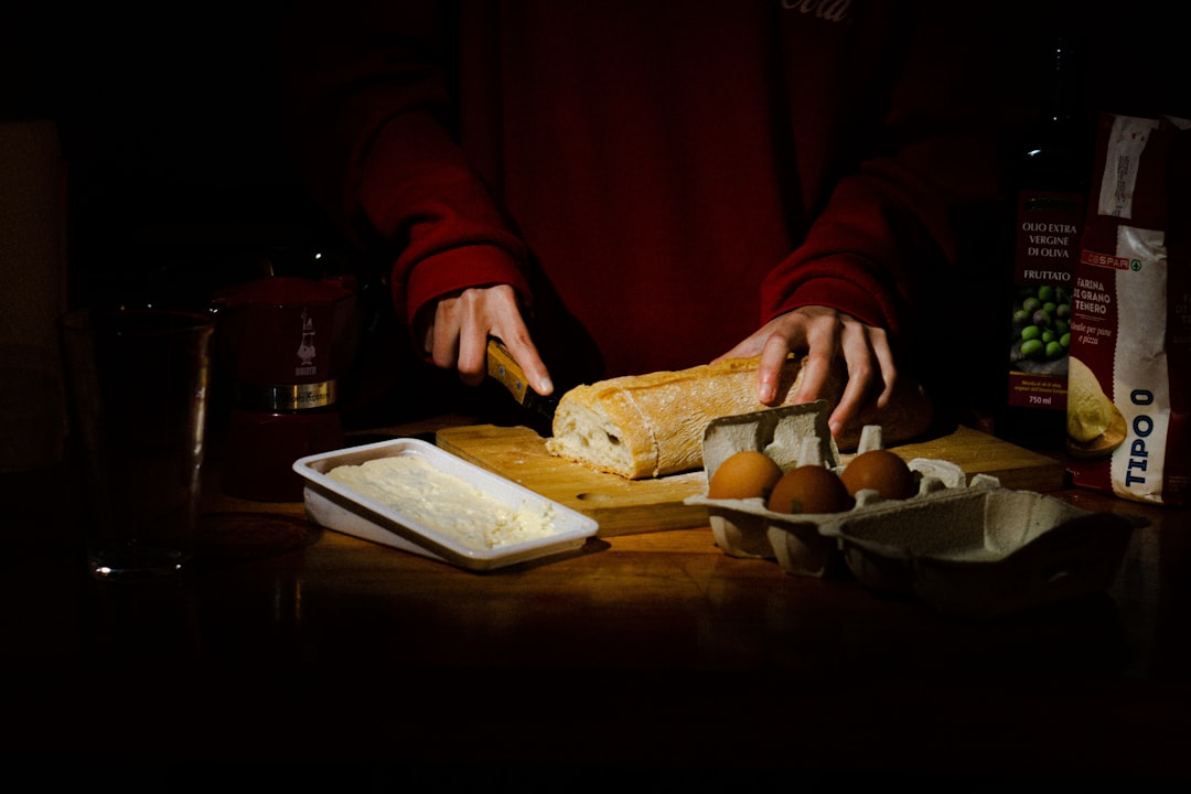 a-person-cutting-a-loaf-of-bread-on-a-cutting-board-a9lz2pwqugy